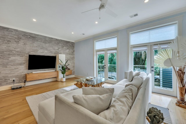 living room featuring ceiling fan, wood-type flooring, ornamental molding, and french doors