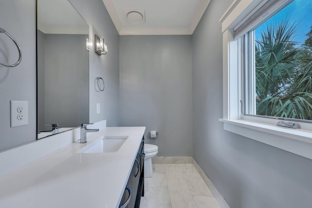 bathroom with vanity, toilet, and plenty of natural light