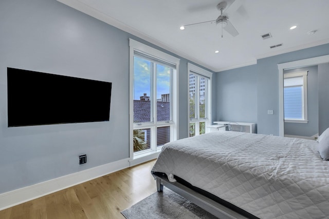 bedroom featuring ceiling fan, ornamental molding, and light hardwood / wood-style flooring