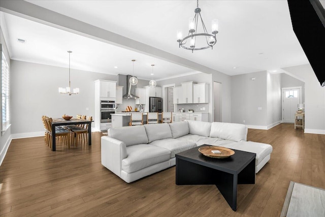 living room featuring crown molding, a chandelier, and dark hardwood / wood-style floors