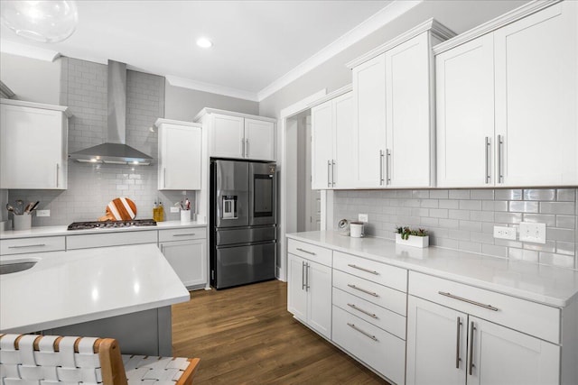 kitchen with wall chimney range hood, tasteful backsplash, dark hardwood / wood-style flooring, white cabinetry, and stainless steel appliances