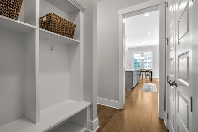 mudroom featuring ornamental molding, sink, an inviting chandelier, and dark hardwood / wood-style flooring