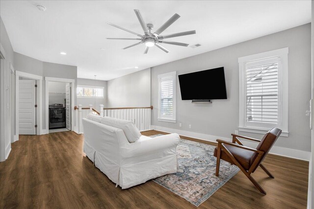 living room featuring ceiling fan, a wealth of natural light, and dark hardwood / wood-style floors