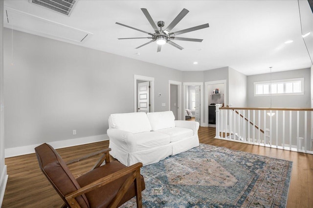 living room featuring dark wood-type flooring and ceiling fan