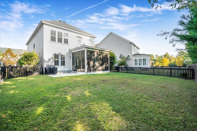 back of house with a yard, a sunroom, and a patio