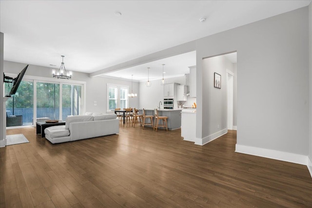 unfurnished living room with an inviting chandelier and dark wood-type flooring