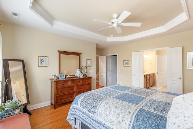 bedroom featuring a raised ceiling, ornamental molding, ceiling fan, and light wood-type flooring