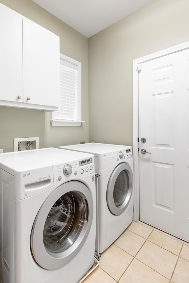 laundry room featuring cabinets, separate washer and dryer, and light tile patterned floors