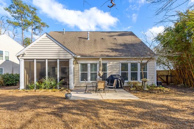 rear view of house with a sunroom, a yard, and a patio