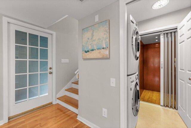 interior space with stacked washer / dryer and hardwood / wood-style flooring