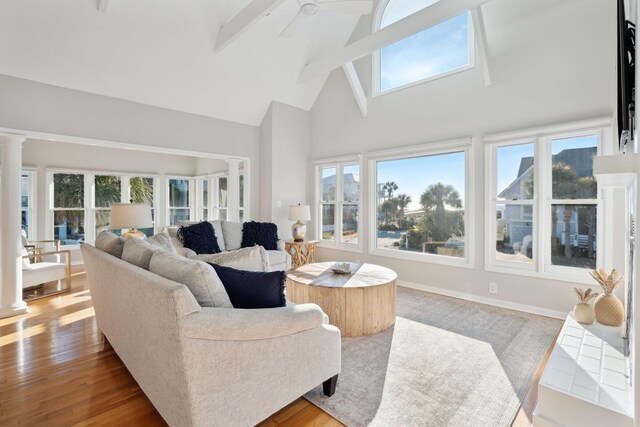 living room with beam ceiling, ceiling fan, high vaulted ceiling, decorative columns, and hardwood / wood-style floors