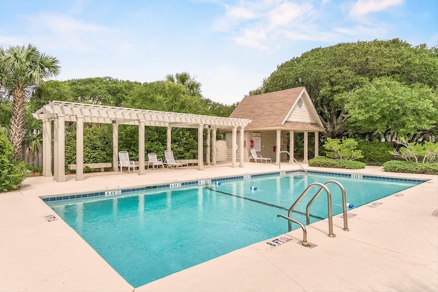 view of pool with a pergola, an outbuilding, and a patio