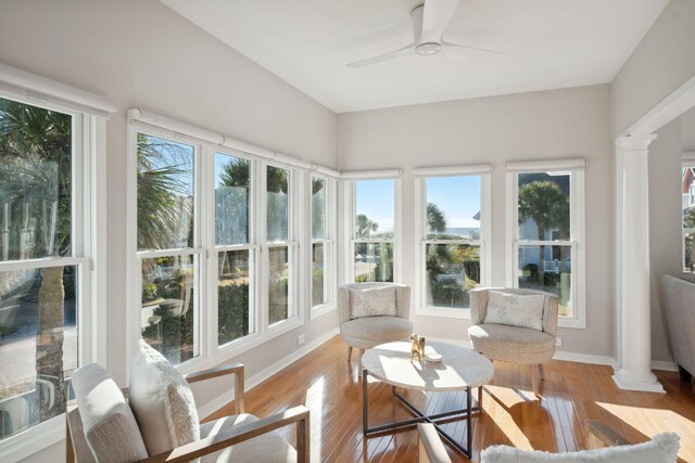 sunroom / solarium with plenty of natural light, ceiling fan, and ornate columns