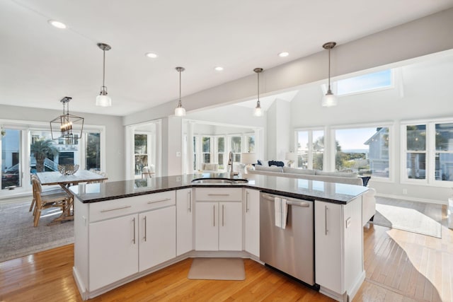 kitchen with sink, light hardwood / wood-style flooring, dishwasher, white cabinets, and hanging light fixtures