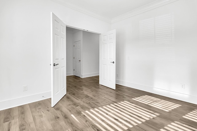 unfurnished bedroom featuring hardwood / wood-style flooring and crown molding