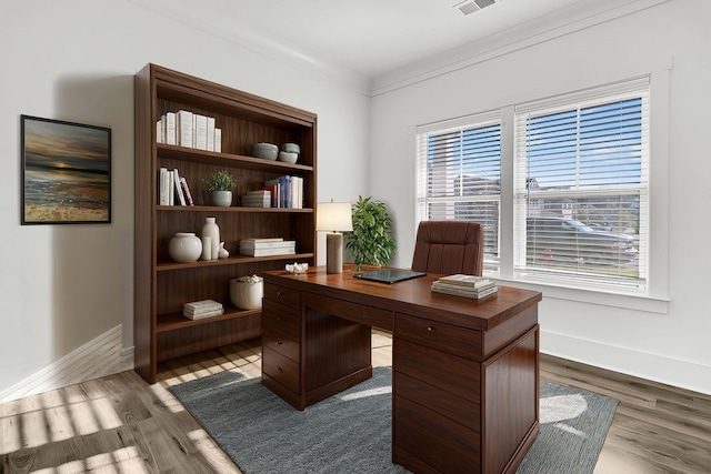 home office featuring light wood-type flooring and crown molding