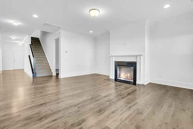 unfurnished living room featuring ornamental molding and hardwood / wood-style floors