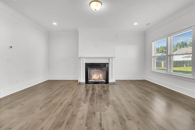 unfurnished living room with hardwood / wood-style flooring and crown molding