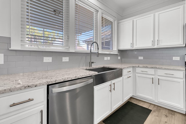 kitchen featuring light hardwood / wood-style floors, sink, light stone countertops, white cabinets, and stainless steel dishwasher