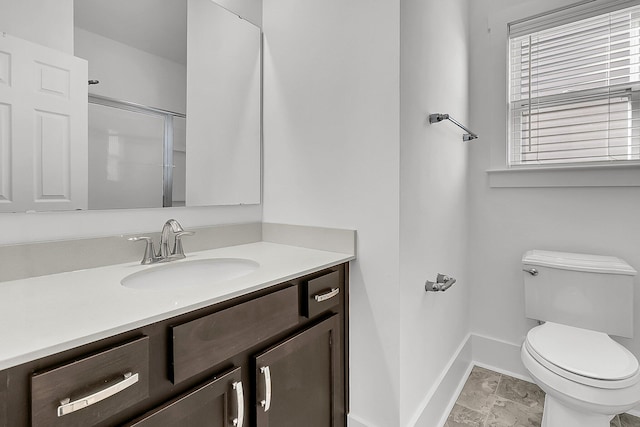 bathroom featuring vanity, toilet, and a shower with door