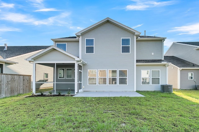 rear view of property with a yard, a patio, and central AC