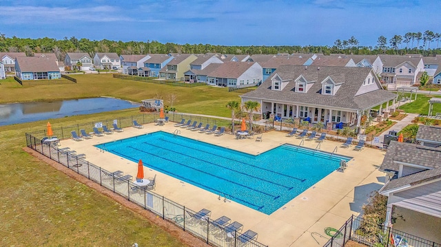 view of swimming pool with a water view, a yard, and a patio area