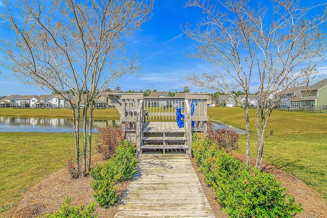 view of dock featuring a water view and a yard