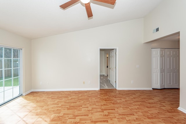 spare room with ceiling fan, high vaulted ceiling, and light hardwood / wood-style flooring