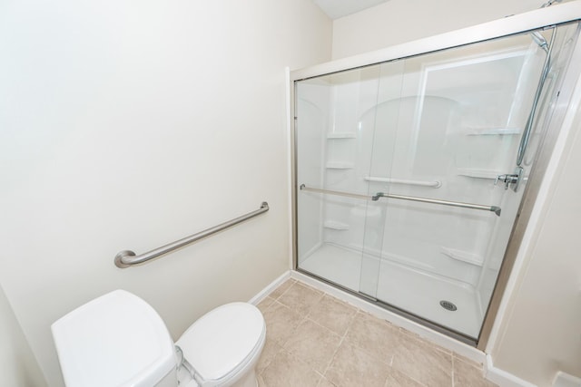 bathroom featuring a shower with shower door, tile patterned floors, and toilet