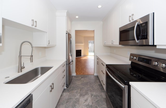 kitchen featuring sink, white cabinets, and appliances with stainless steel finishes