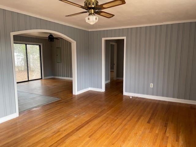 empty room with ceiling fan, light hardwood / wood-style flooring, and crown molding