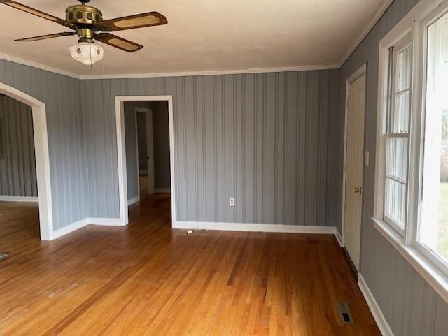 unfurnished room with light hardwood / wood-style floors, ornamental molding, and ceiling fan