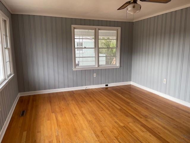 unfurnished room with crown molding, ceiling fan, and light hardwood / wood-style floors