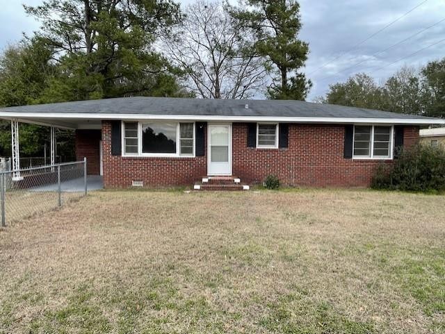 ranch-style house with a carport and a front lawn