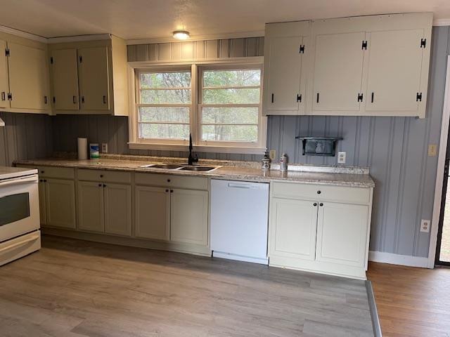 kitchen featuring light wood-type flooring, sink, and white appliances