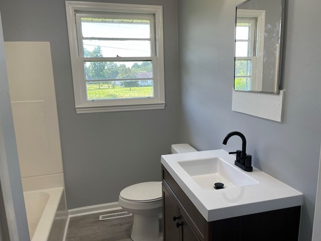 full bathroom featuring hardwood / wood-style floors, plenty of natural light, toilet, and vanity