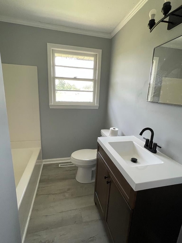 bathroom featuring ornamental molding, vanity, hardwood / wood-style floors, and toilet