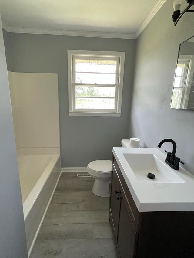 full bathroom with washtub / shower combination, hardwood / wood-style floors, vanity, ornamental molding, and toilet