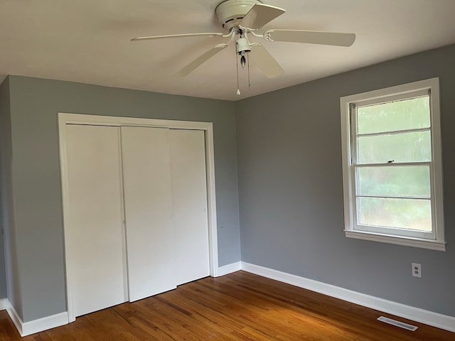 unfurnished bedroom featuring ceiling fan, a closet, and wood-type flooring