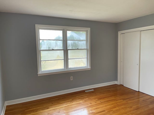 unfurnished bedroom with a closet and light hardwood / wood-style flooring