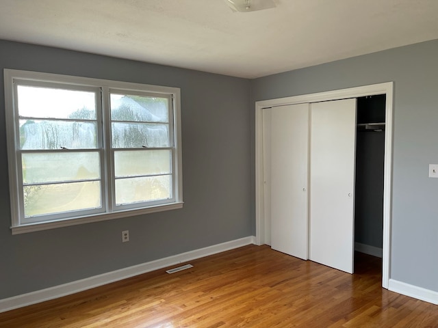 unfurnished bedroom featuring hardwood / wood-style flooring and a closet