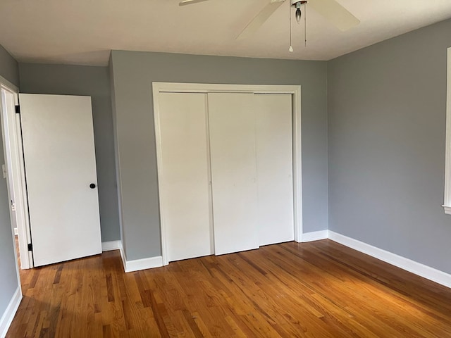 unfurnished bedroom featuring ceiling fan, a closet, and hardwood / wood-style floors