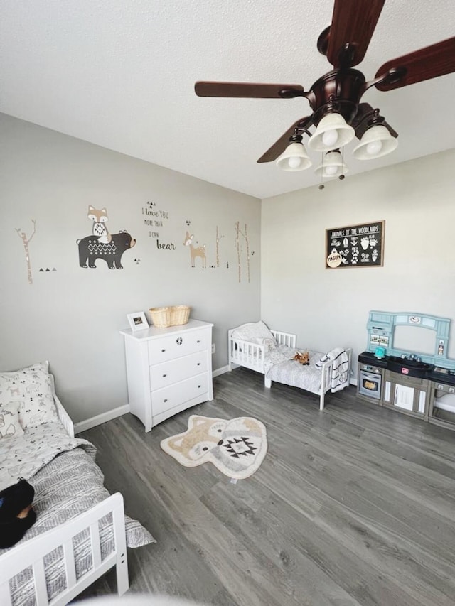 bedroom featuring dark hardwood / wood-style floors, a textured ceiling, and ceiling fan