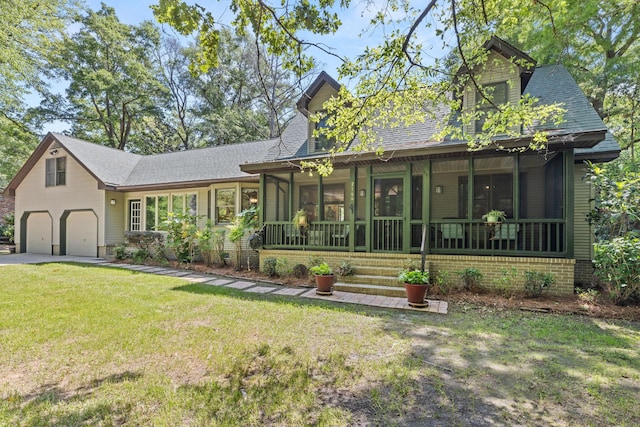 2144 Pinopolis Rd, Pinopolis, SC 29469 - view of front facade featuring a front lawn, driveway, an attached garage, a shingled roof, and a sunroom