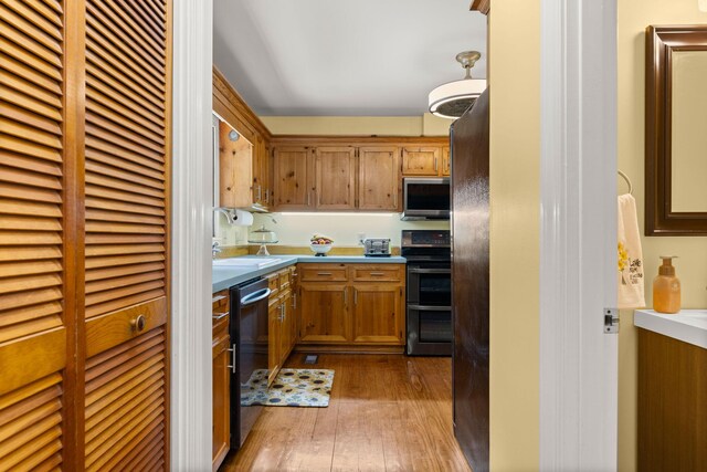2144 Pinopolis Rd, Pinopolis, SC 29469 - kitchen with stainless steel appliances, light countertops, a sink, brown cabinets, and hardwood / wood-style flooring