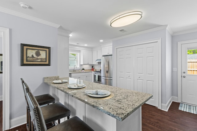 kitchen featuring stainless steel appliances, visible vents, white cabinetry, a peninsula, and dark wood-style flooring