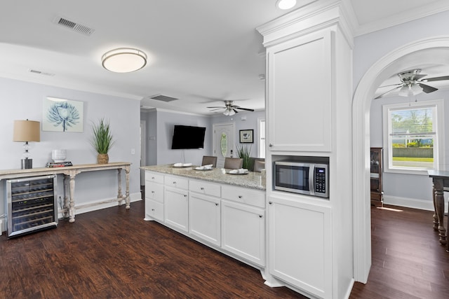 kitchen with visible vents, beverage cooler, stainless steel microwave, and ceiling fan