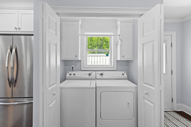 clothes washing area with separate washer and dryer, baseboards, cabinet space, and crown molding