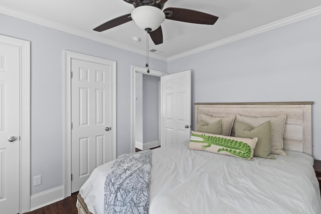 bedroom featuring crown molding, a ceiling fan, dark wood finished floors, baseboards, and visible vents