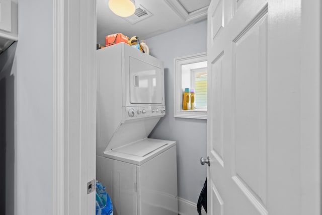 laundry area with stacked washer / drying machine, visible vents, and laundry area
